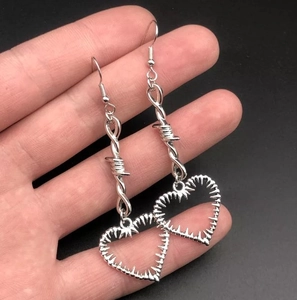 Détails macro de boucles d'oreilles cœur épineux punk avec finition en métal argenté