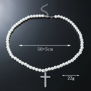 Détail du collier de perles blanches avec croix en strass mesurant 50cm plus l'extension