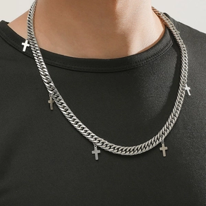 Collier à mailles gourmette argenté avec cinq petits pendentifs en croix sur un t-shirt noir