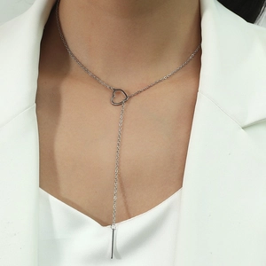 Collier lariat cœur en acier inoxydable minimaliste porté sur une tenue blanche chic