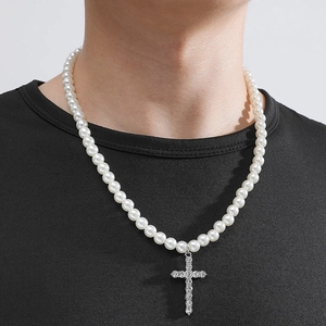 Détail du collier de perles avec pendentif croix glacé sur un t-shirt noir