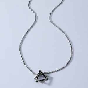Close-up of interlocking geometric triangular pendant in black and silver titanium steel