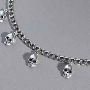 Punk style silver alloy necklace featuring detailed skull pendants and thick Cuban chain
