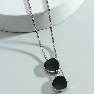 Hip hop sunglasses pendant necklace in stainless steel on white geometric pedestal