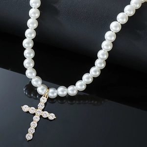 Collier élégant en perles blanches avec un pendentif croix dorée serti de diamants