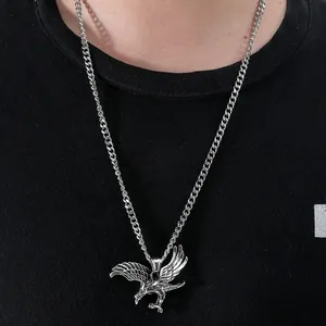 Détail du pendentif aigle argenté aux ailes finement sculptées sur chaîne gourmette