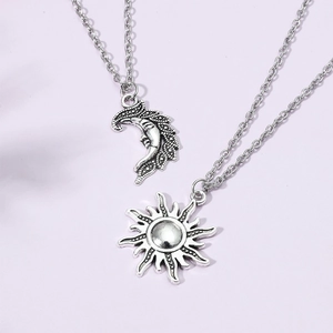 Detail of vintage silver sun and moon pendant necklaces on a purple background