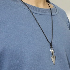 Spearhead pendant necklace with lava stone beads and black cord on a blue hoodie