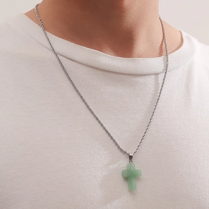 Close-up of a men's silver rope chain with a light green crystal cross stone pendant