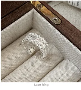Macro shot of S925 sterling silver lace pattern ring on a vintage wooden jewelry box