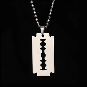 Detailed view of a silver razor blade pendant on a ball chain with a punk rock aesthetic