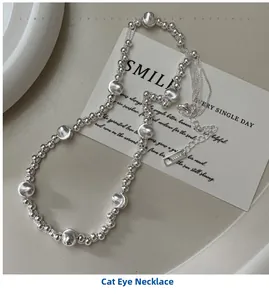 Macro detail of S925 sterling silver beaded necklace with cat-eye beads and heart tag