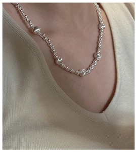 Close-up of S925 sterling silver beaded necklace with cat eye beads on model