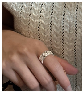 Detail of vintage silver lace ring with hollow woven texture on woman's finger