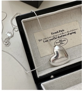 Detailed close-up of S925 sterling silver heart pendant with polished snake chain finish