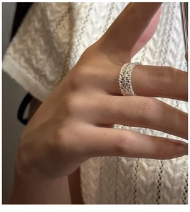 Detail of a wide S925 sterling silver hollow lattice ring worn on index finger