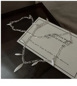 Close-up of S925 sterling silver Figaro chain necklace with bamboo leaf pendant details