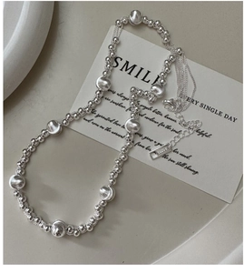 Macro detail of S925 sterling silver beaded necklace with mixed texture round beads on tray