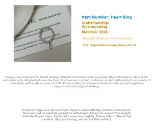Macro detail of S925 sterling silver beaded ring with heart charm and elastic band