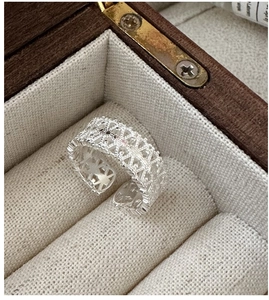 Detail of S925 sterling silver lace ring with hollow pattern in a wooden jewelry box