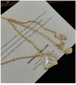 Detail of S925 silver heart necklace with matte gold finish and textured inlay
