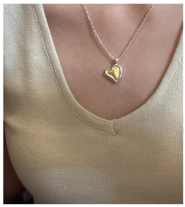 Macro detail of dual-tone 925 silver heart necklace with hammered texture finish