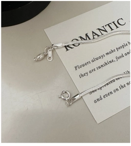 Detailed macro view of S925 sterling silver snake chain bracelet with pearl and spring clasp
