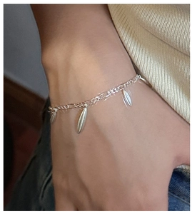 Close-up of S925 sterling silver drop charm bracelet worn on a female wrist