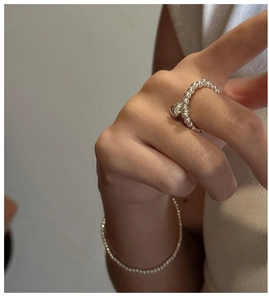 Macro shot of S925 sterling silver beaded ring with heart charm on hand