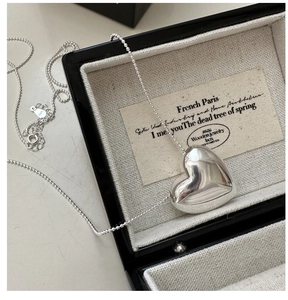 Close-up of polished S925 sterling silver heart pendant on a delicate ball chain