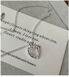 Gros plan détaillé du collier coeur en argent sterling S925 avec texture martelée