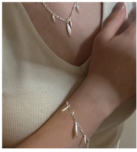 Detail of silver S925 sterling silver olive leaf necklace and bracelet set on model