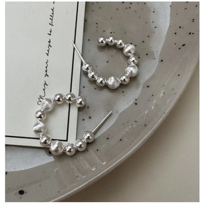 Detail of S925 silver C-shaped beaded earrings with polished and brushed textures