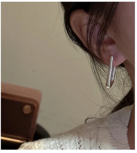 Dettaglio dell'orecchino a U minimalista in argento S925 indossato sull'orecchio donna