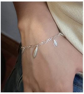 Detail view of S925 sterling silver water drop charms on a minimalist chain bracelet