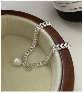 Gros plan d'un bracelet gourmette en argent S925 avec pendentif en perle baroque
