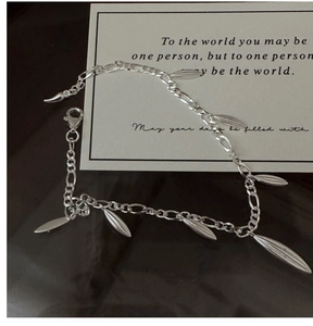 Detail of S925 sterling silver Figaro chain with leaf tassels and lobster clasp closure