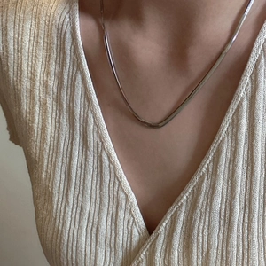 S925 sterling silver flat snake chain necklace worn by a model on a knit top