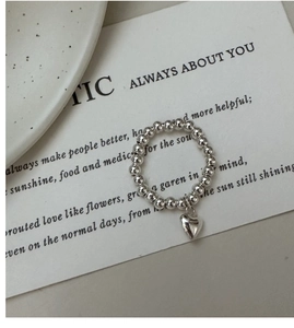 Close-up of S925 sterling silver beaded heart ring on a minimalist ceramic tray