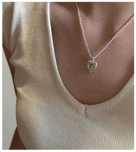 Détail d'un collier en argent S925 avec pendentif coeur vert porté par un mannequin