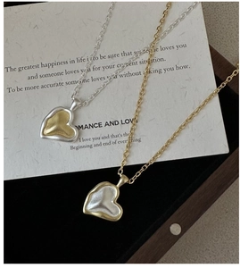 Detailed close-up of 925 silver heart necklaces with contrast matte gold and silver finish
