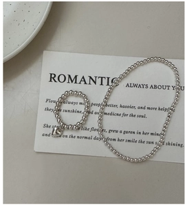 Detailed macro view of S925 sterling silver beaded ring with heart charm and matching bracelet