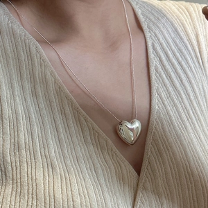 Minimalist S925 silver heart pendant necklace on sleek ball chain worn with beige knitwear