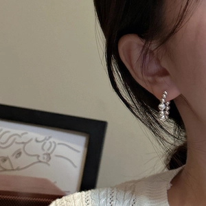 S925 sterling silver C-shaped hoop earrings with cat-eye beads on an elegant female model