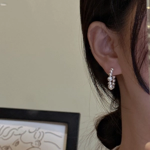 Elegant S925 sterling silver beaded hoop earrings worn by a model in a minimalist style