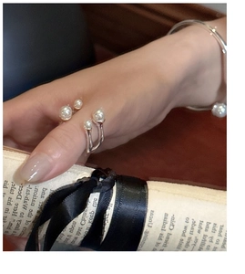 Close-up of S925 sterling silver pearl ring and bracelet with elegant intertwined design