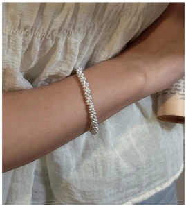 Macro detail of S925 sterling silver beaded bracelet with a fine triple-strand wire design