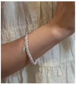 Detail view of S925 sterling silver beaded bracelet with polished rectangular charm on wrist