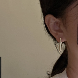 Eleganti orecchini a U in argento S925 dorato indossati da una modella in stile minimalista