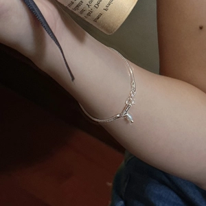 S925 sterling silver snake chain bracelet featuring a delicate pearl charm on a model's wrist